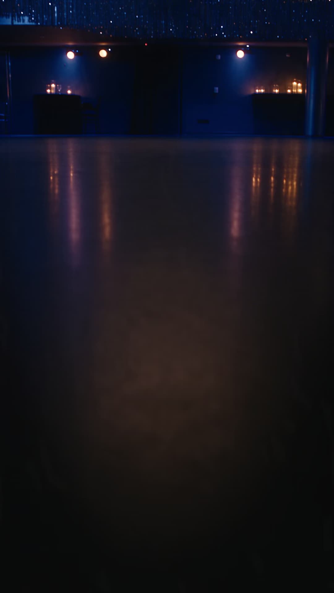 Modern midnight-blue event room with silver streamers.