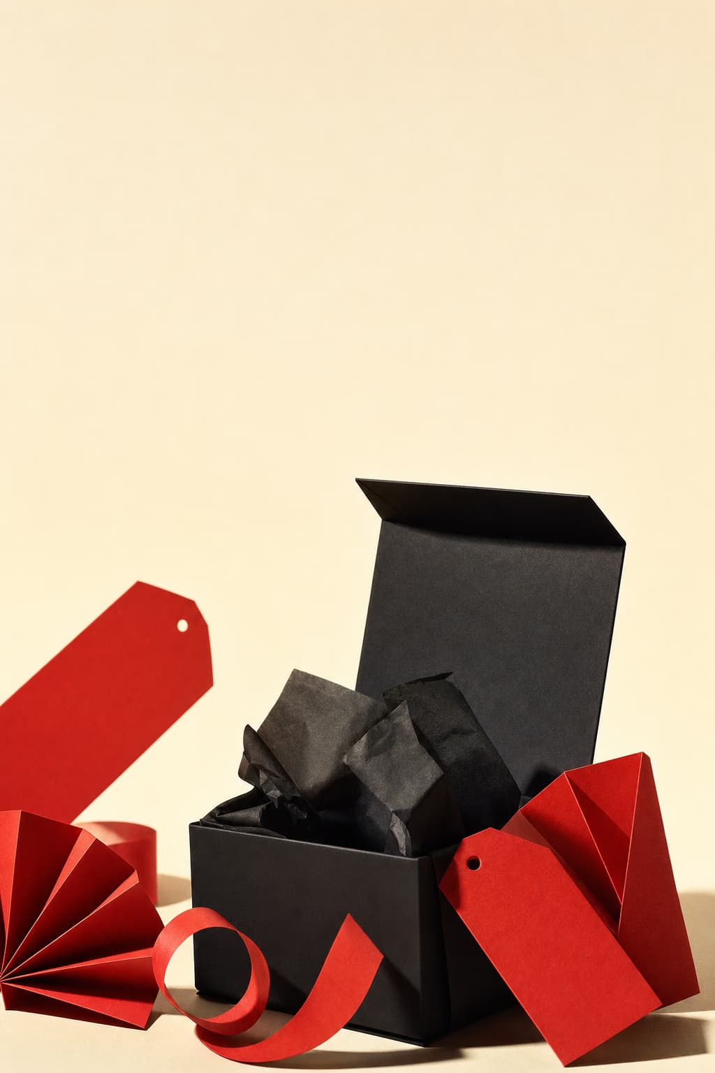 Black gift box with scarlet paper sale shapes.