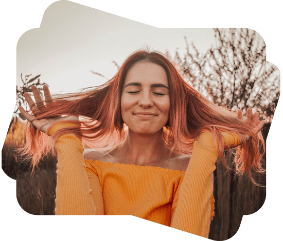 red hair girl with closed eyes wearing orange sweeter smiling