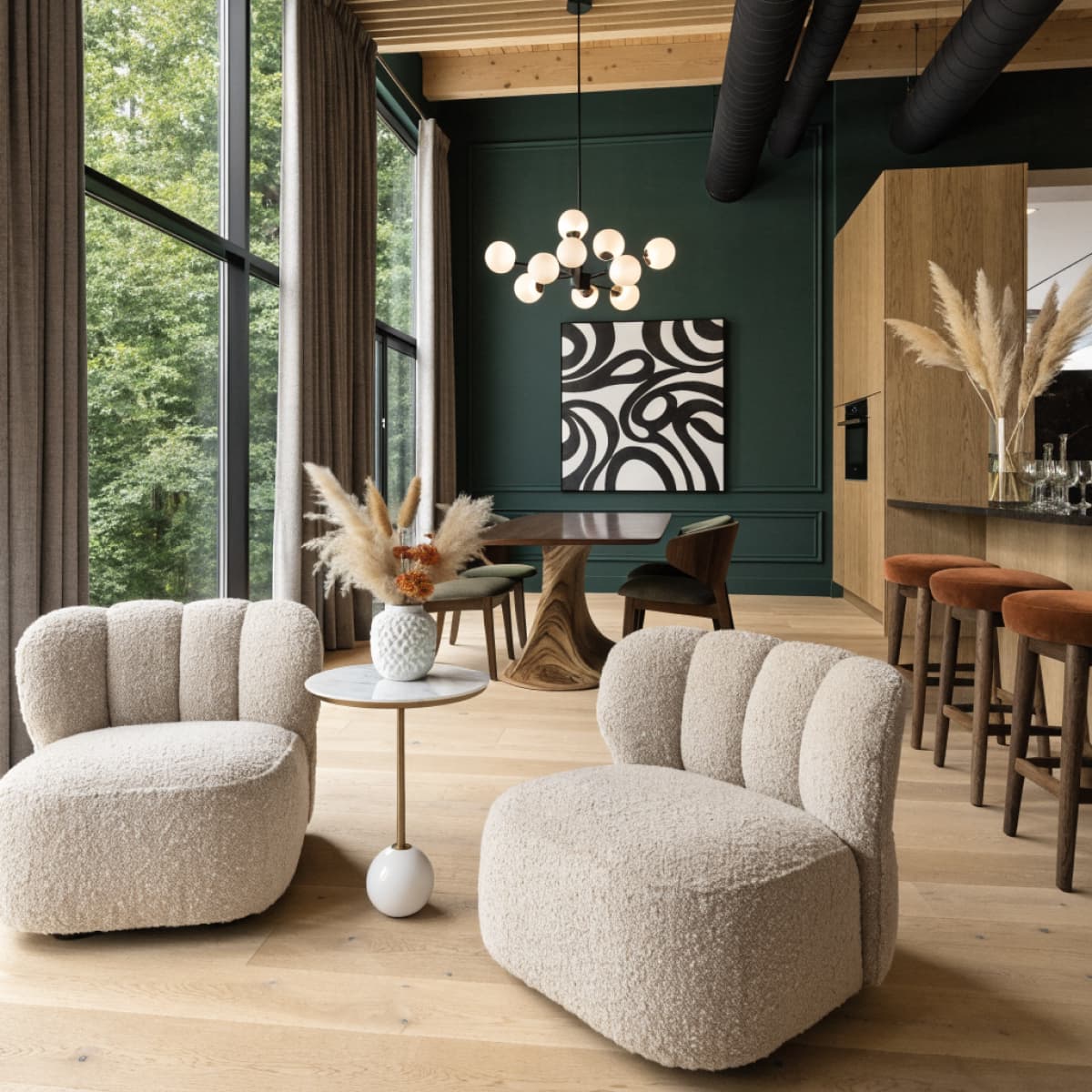 Lounge with boucle armchairs and a dark green accent wall